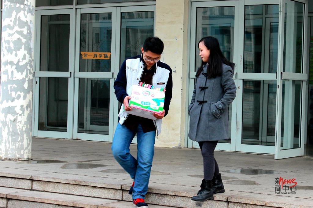 工科班里女生少,男生自然要多多照顾她们——搬书这种体力活儿还是交给他吧。(屈升 摄)