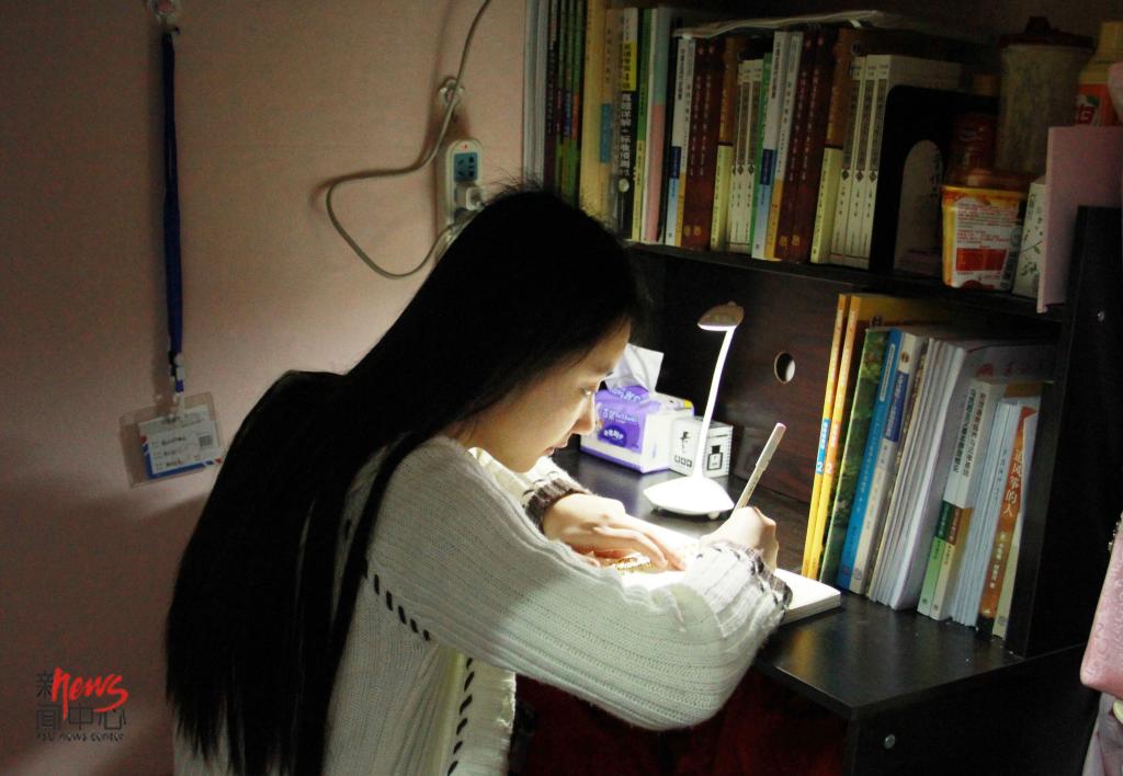 不知从什么时候起,她开始喜欢每天晚上睡觉前写一篇日记,也许这一天很平淡,但一天天记下来,以后回忆大学生活的时候会更有意义吧。(李晖 摄)